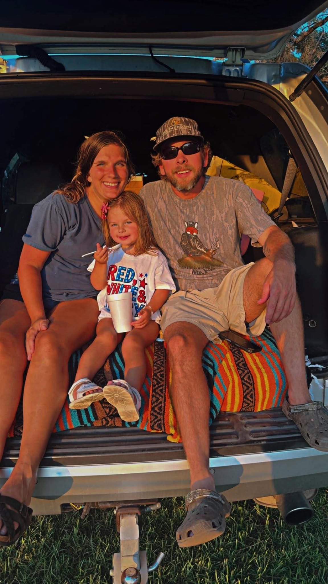 Family and friends smiling together on a boat.