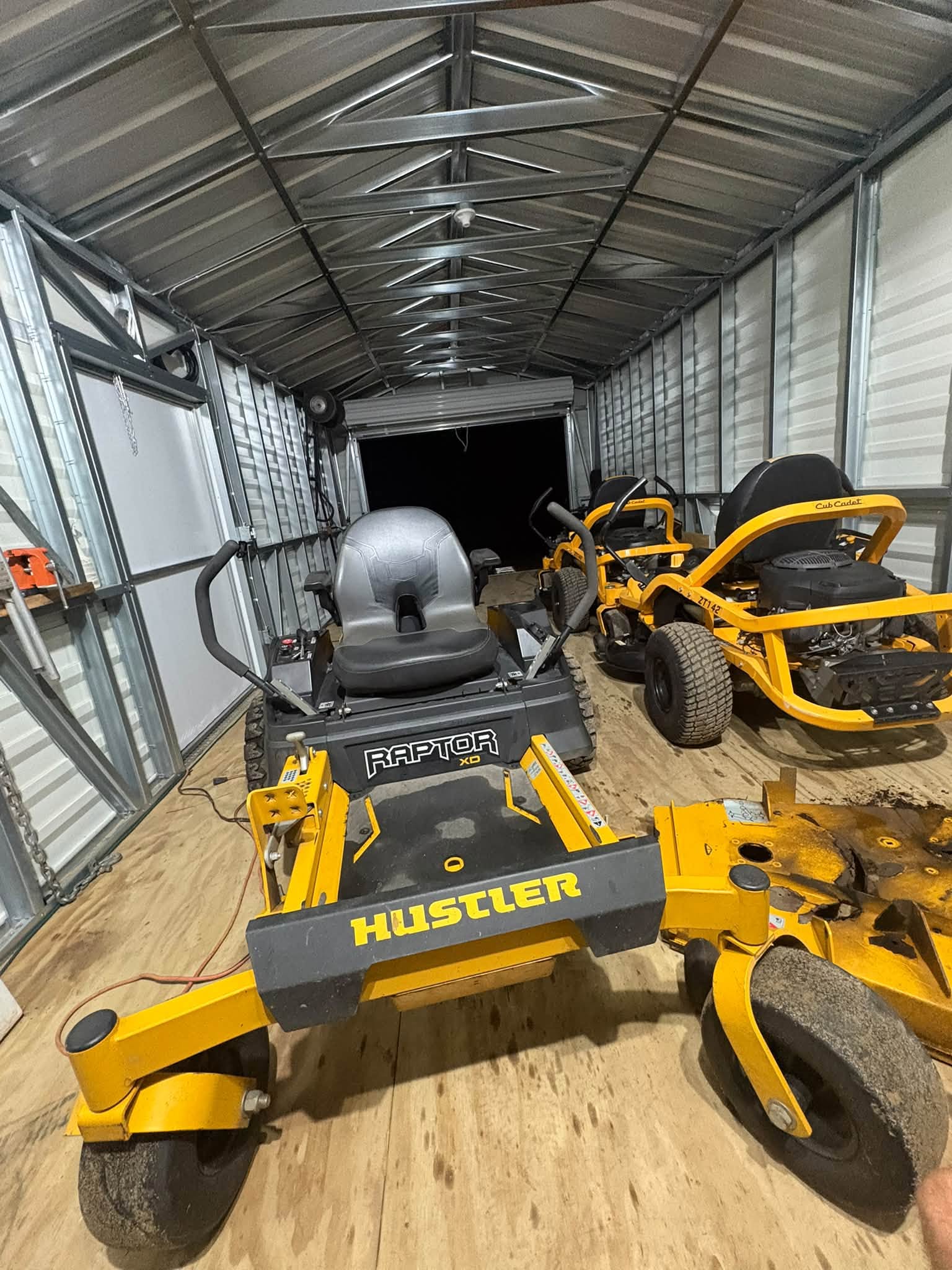 Yellow marine or auto equipment parked beneath a metal canopy structure.